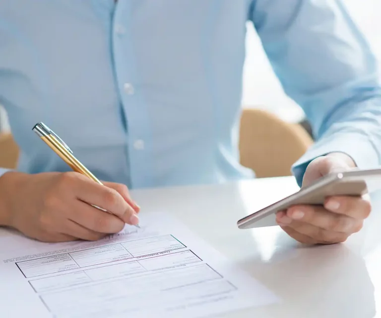 closeup-woman-signing-document-holding-smartphone